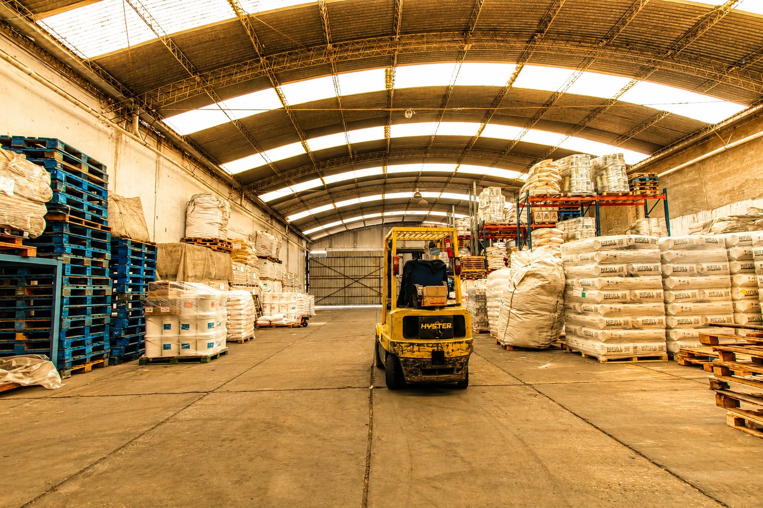 Nave del depósito con pallets, big bags y autoelevador